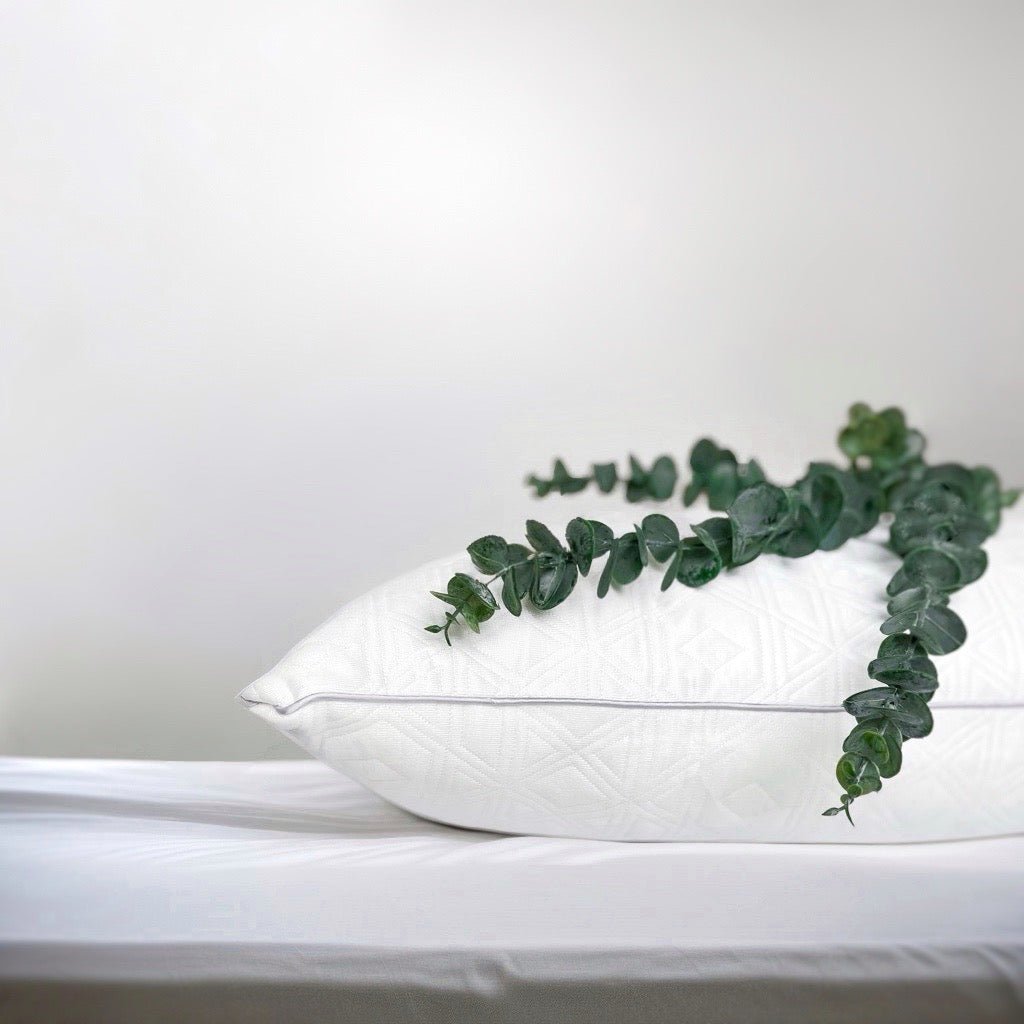 Wit OnePillow hoofdkussen op een licht bed