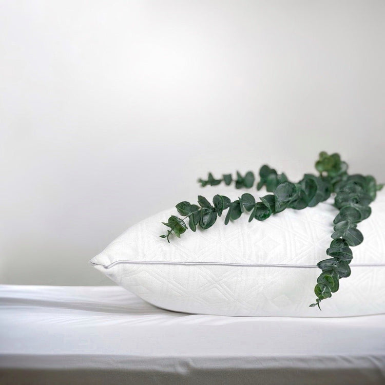 Wit OnePillow hoofdkussen op een licht bed